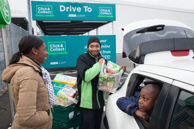 A colleague loads a family's groceries into their car