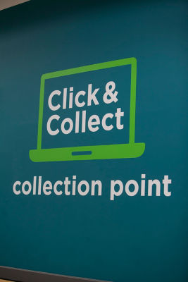 A blue wall features a painted "Click & Collect Collection Point" sign