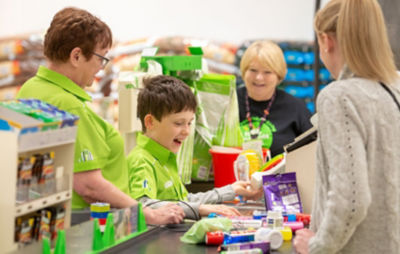Colleagues at Asda Falkirk show Aaron how to work a checkout