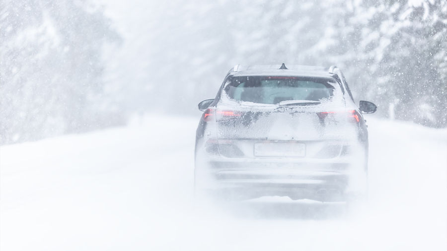 Image of car driving in the snow.