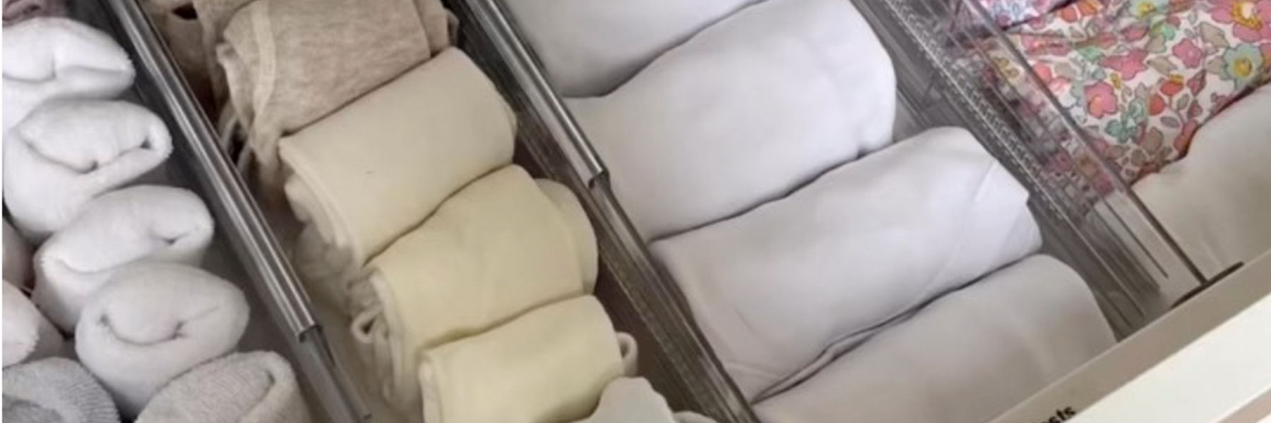 Folded baby clothes in a drawer