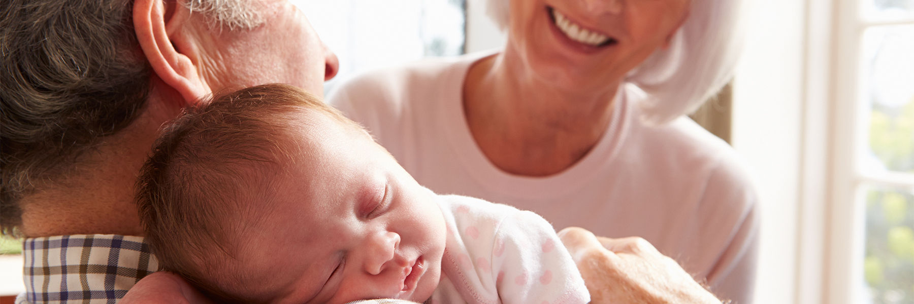 Grandparents holding newborn baby