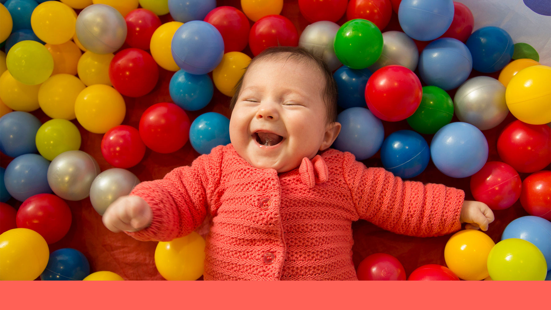 Baby playing in a ball pit