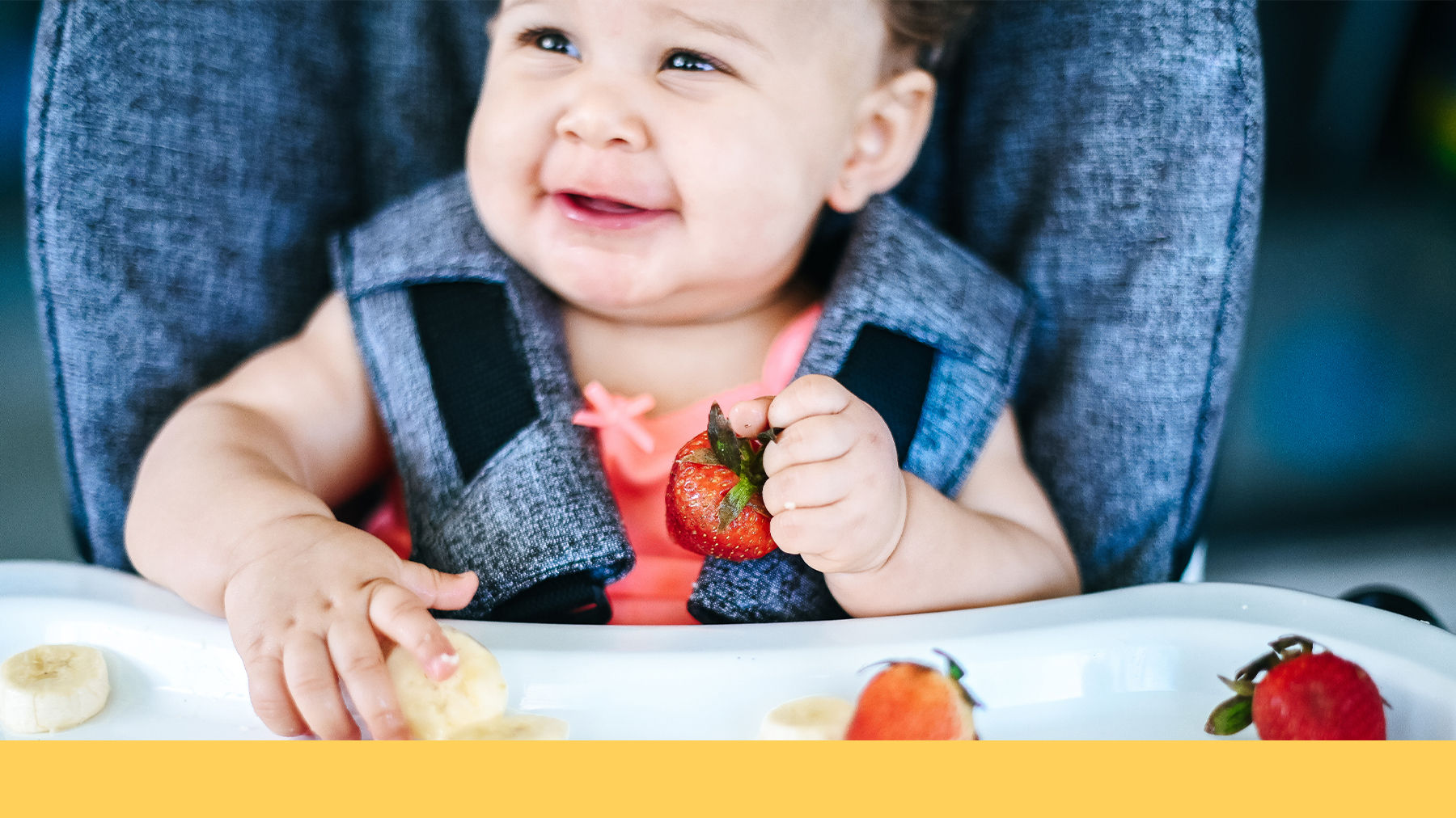 Baby eating strawberries and banana