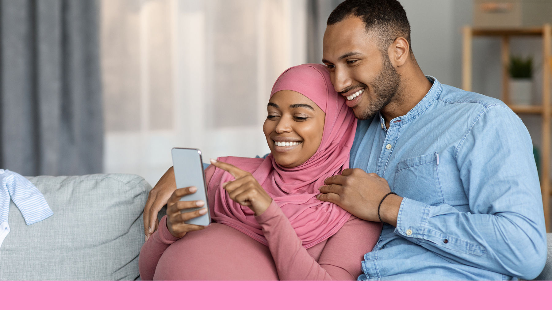 Couple sitting on the sofa looking at a phone