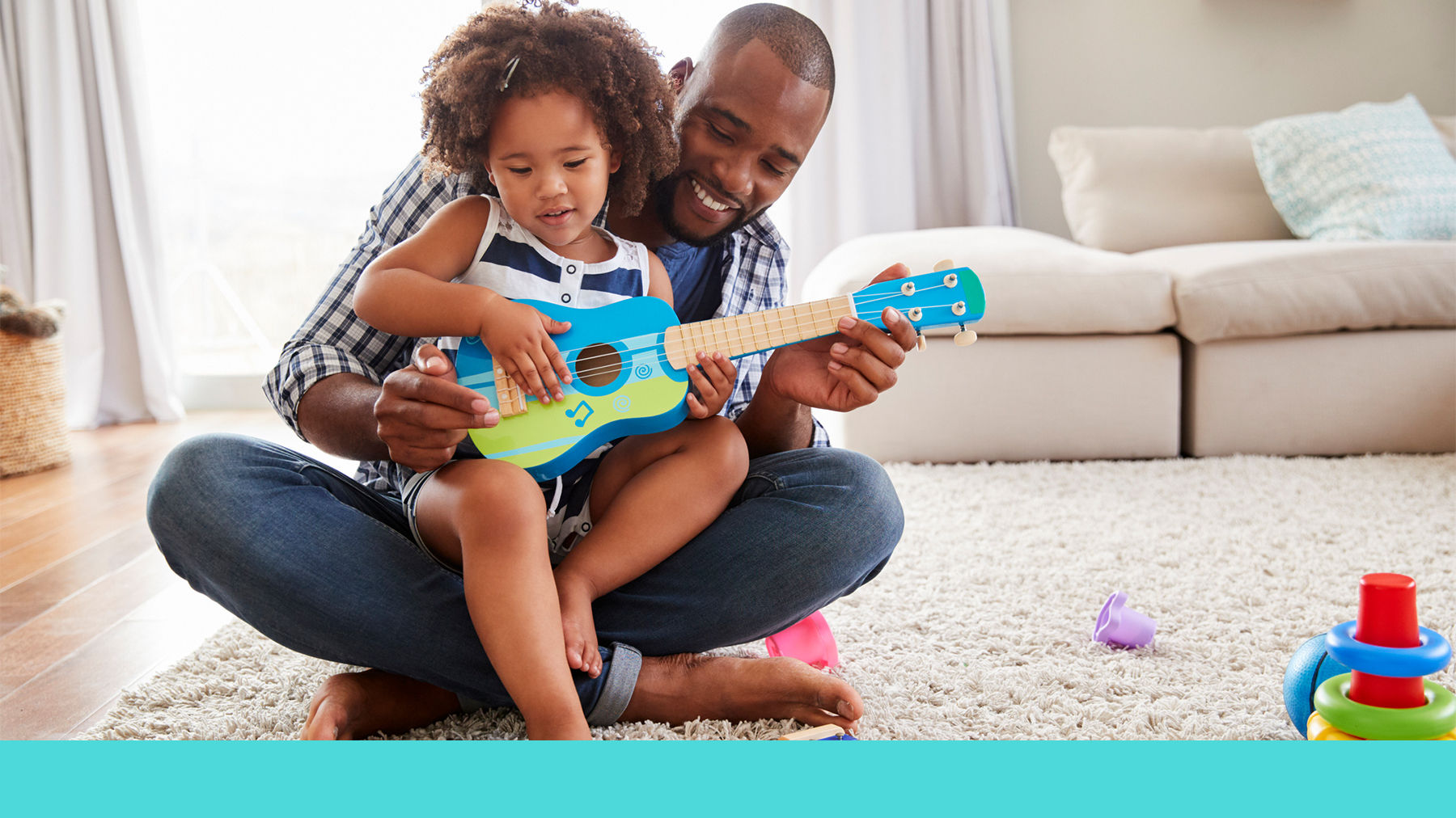 Father playing guitar with toddler
