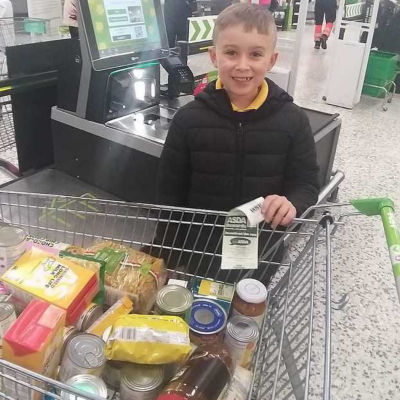 Hayden Santer, whose dad Matt works at Asda Blyth, with his donation to Blyth Food Bank