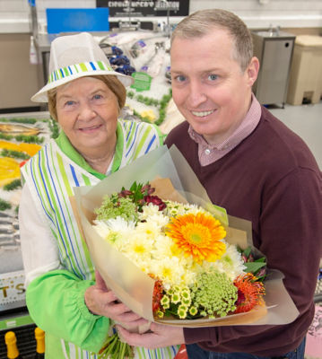 Jason Clark from Asda Carlisle gives Freda Mounsey a bunch of flowers for her 80th birthday