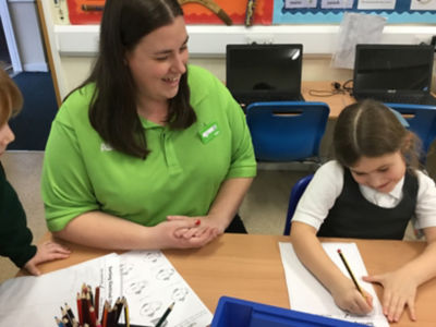 Asda Romford community champion Liz  Brown helps a pupil