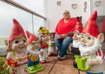 Janet Wilson on her balcony with a collection of 40 Asda gnomes