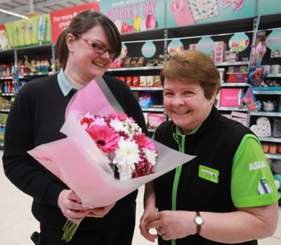 Rachelle presenting Jacqui (right) with flowers to mark Mother's Day at Asda Larne