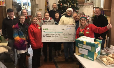 Asda Pwllheli community champion Jo Scott presenting the group with their surprise Christmas cheque