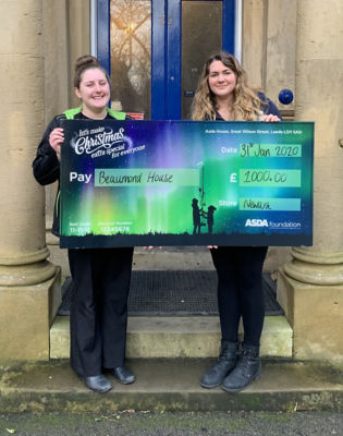 Kat from Beaumond House in Newark picks up an Asda Foundation cheque for £1,000