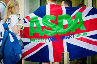 An Asda colleague walks with a UK flag behind him