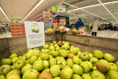 Children pick up a free Bramley apple from Asda West Bridgford
